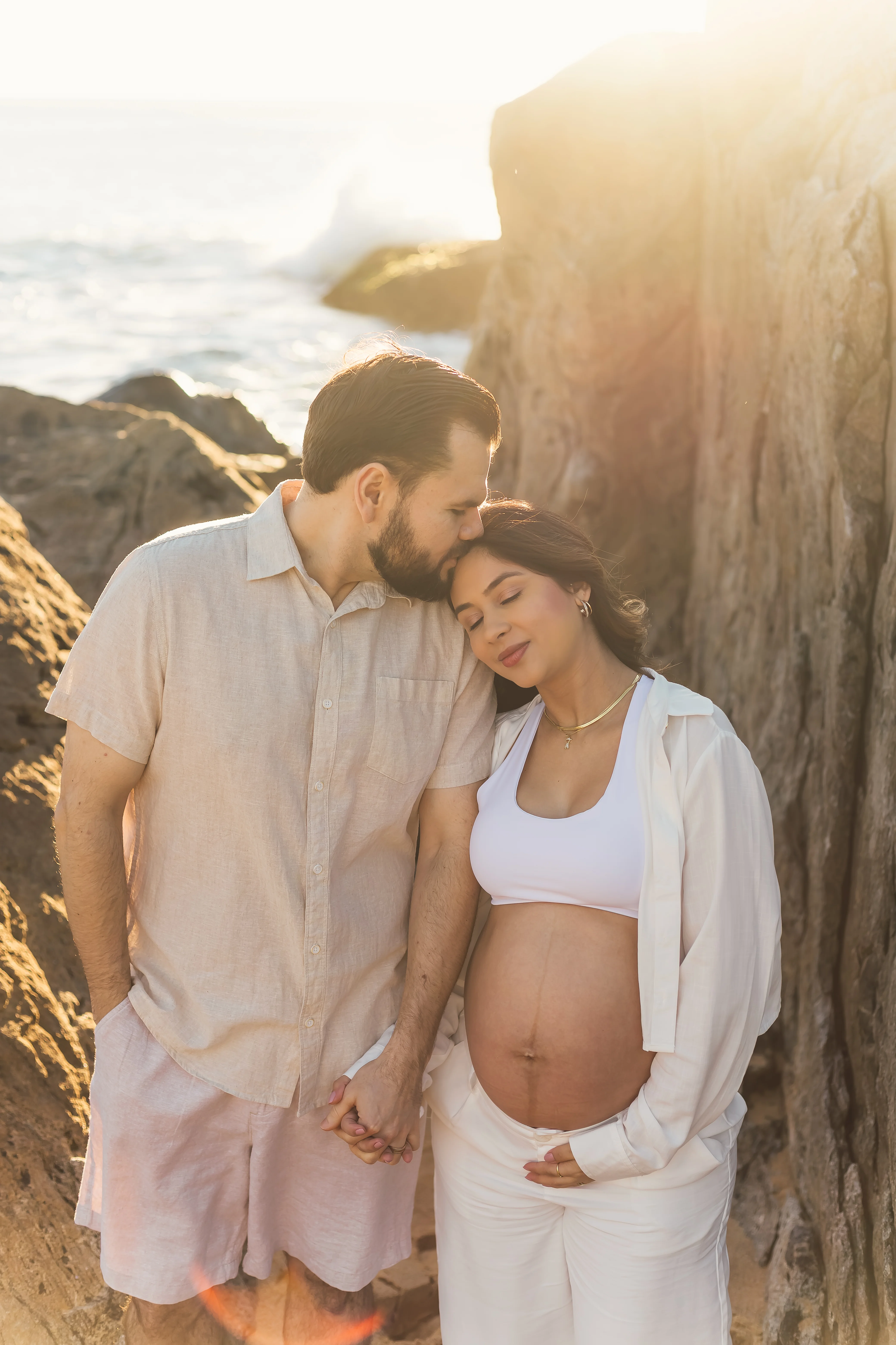 Casal gestante nas pedras ao entardecer