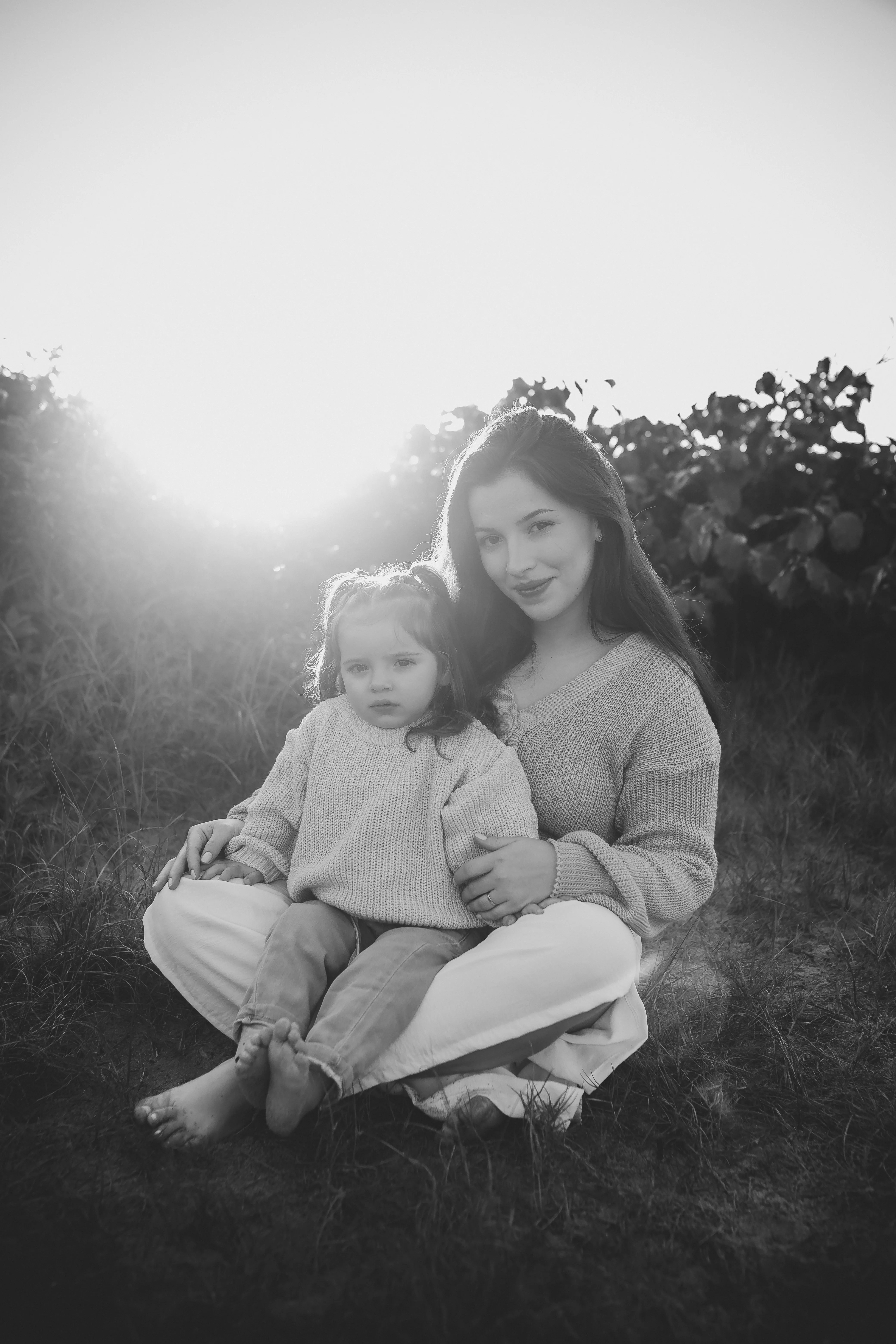 Mãe e filha no campo ao pôr do sol em P&B